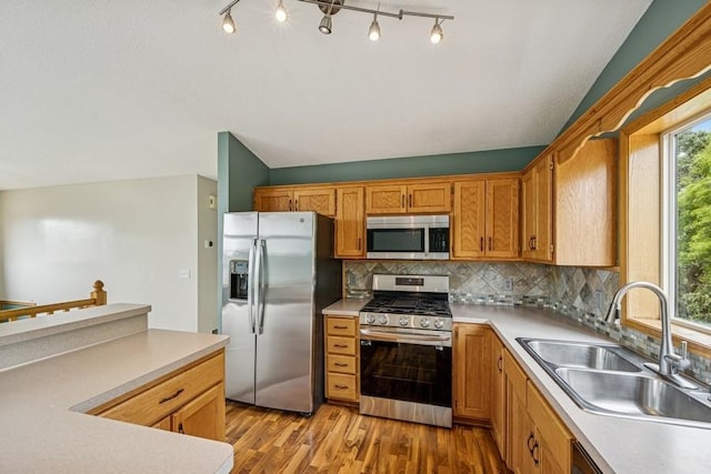 15271 Sodium St NW, Ramsey, MN 55303 - kitchen featuring stainless steel appliances, backsplash, light wood-style flooring, light countertops, and lofted ceiling