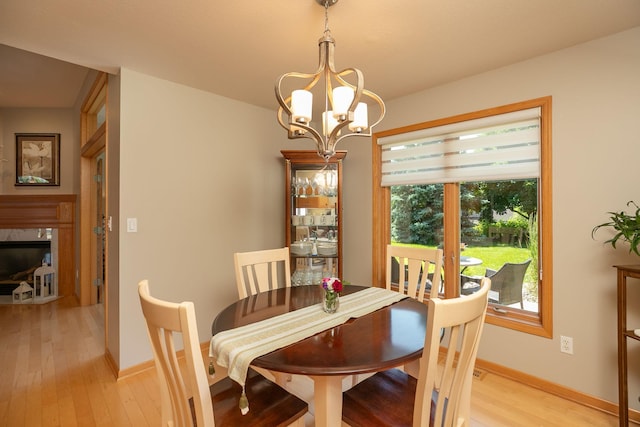 5209 Goodview Ln NW, Rochester, MN 55901 - dining room with light wood finished floors, healthy amount of natural light, a chandelier, and a high end fireplace