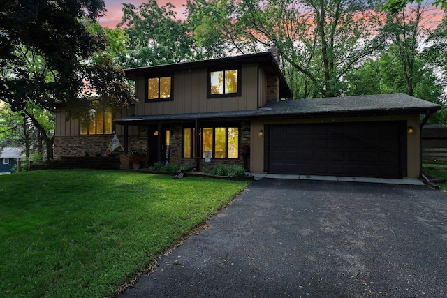 9009 44th Cir N, New Hope, MN 55428 - view of front facade featuring a yard, an attached garage, driveway, and board and batten siding