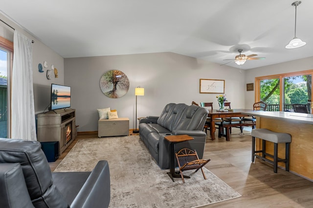 9009 44th Cir N, New Hope, MN 55428 - living room featuring a ceiling fan, light wood-style floors, lofted ceiling, and a lit fireplace