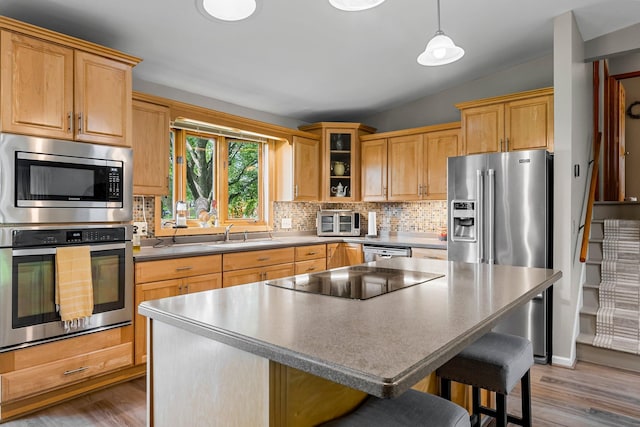 9009 44th Cir N, New Hope, MN 55428 - kitchen featuring appliances with stainless steel finishes, decorative backsplash, wood finished floors, a kitchen breakfast bar, and lofted ceiling