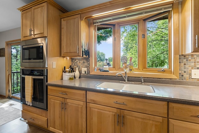 9009 44th Cir N, New Hope, MN 55428 - kitchen with appliances with stainless steel finishes, tasteful backsplash, dark countertops, and brown cabinetry