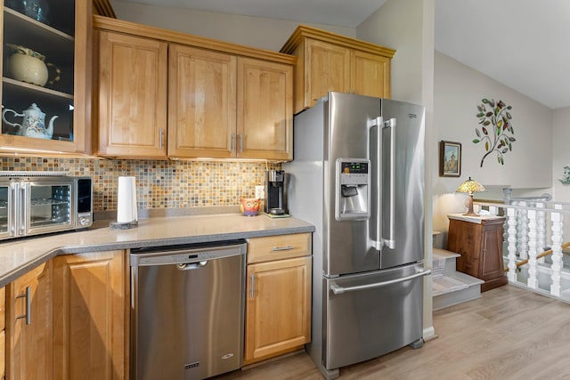 9009 44th Cir N, New Hope, MN 55428 - kitchen featuring stainless steel appliances, lofted ceiling, light wood-style flooring, decorative backsplash, and glass insert cabinets