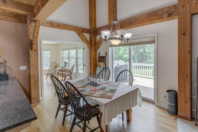5393 Bachelor Rd NW, Hackensack, MN 56452 - dining space with beamed ceiling, a chandelier, light wood finished floors, and healthy amount of natural light