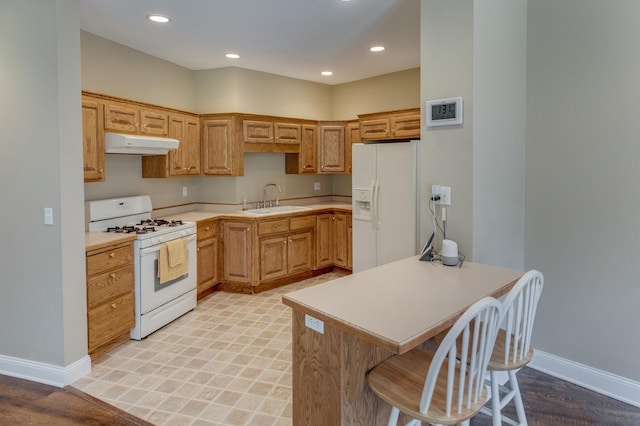 5393 Bachelor Rd NW, Hackensack, MN 56452 - kitchen with white appliances, under cabinet range hood, light countertops, a kitchen bar, and recessed lighting