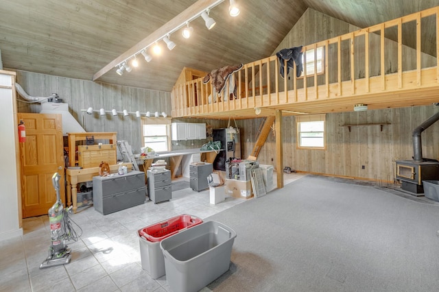 5393 Bachelor Rd NW, Hackensack, MN 56452 - living room with track lighting, a wood stove, high vaulted ceiling, wood walls, and light tile patterned flooring