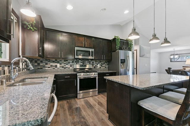 1465 19th St SE, Saint Cloud, MN 56304 - kitchen featuring stainless steel appliances, vaulted ceiling, dark wood finished floors, backsplash, and a breakfast bar