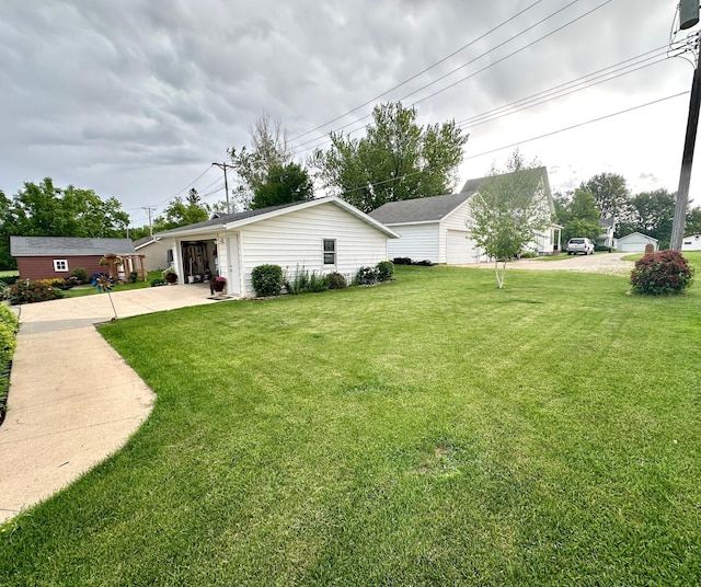 607 Washington Ave, Spring Valley, MN 55975 - view of green lawn with concrete driveway and an outbuilding