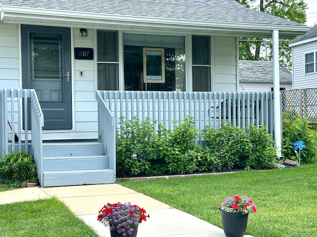 607 Washington Ave, Spring Valley, MN 55975 - doorway to property featuring roof with shingles, covered porch, and a yard