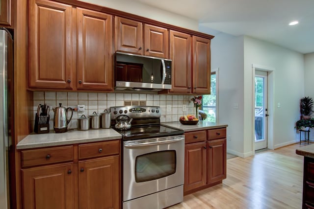 1403 Elm Ave W, Menomonie, WI 54751 - kitchen featuring stainless steel appliances, tasteful backsplash, light wood-type flooring, brown cabinets, and recessed lighting