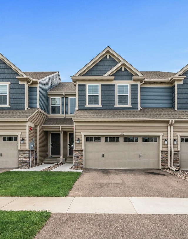 1771 Emerson Ct, Chaska, MN 55318 - view of front of house with stone siding, asphalt driveway, and a garage