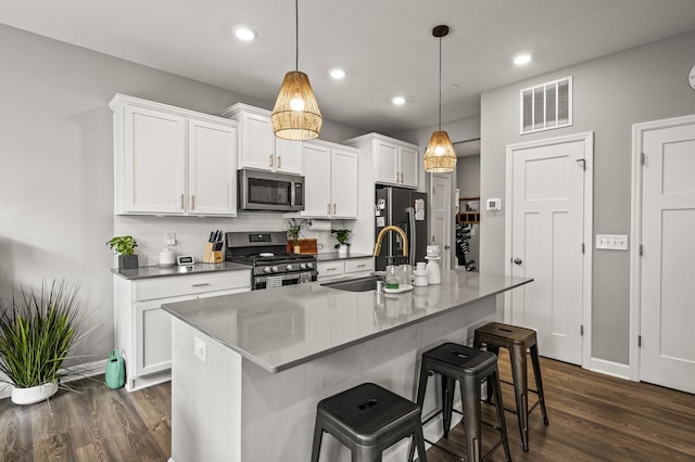 1771 Emerson Ct, Chaska, MN 55318 - kitchen with appliances with stainless steel finishes, dark wood-style floors, backsplash, white cabinets, and recessed lighting