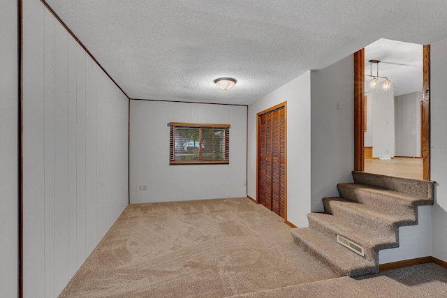 920 2nd Ave S, Sauk Rapids, MN 56379 - stairway featuring carpet, a textured ceiling, and wooden walls