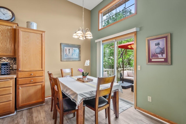 3123 Legacy Ln, Woodbury, MN 55129 - dining area featuring a high ceiling, light wood-style flooring, a chandelier, and healthy amount of natural light
