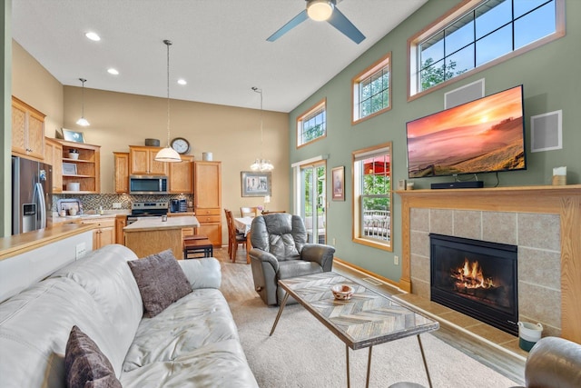 3123 Legacy Ln, Woodbury, MN 55129 - living room featuring a fireplace, ceiling fan, recessed lighting, a high ceiling, and a chandelier