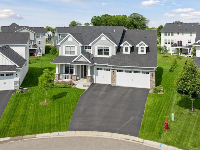 7154 Alphabet St, Chanhassen, MN 55317 - view of front facade featuring stone siding, asphalt driveway, a residential view, a porch, and roof with shingles