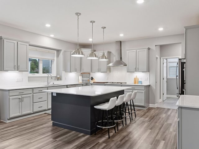 7154 Alphabet St, Chanhassen, MN 55317 - kitchen featuring wall chimney range hood, recessed lighting, backsplash, a center island, and light countertops
