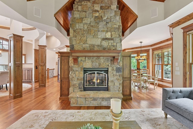 1904 Linner Rd, Minnetonka, MN 55391 - living room with wood-type flooring, a high ceiling, a stone fireplace, and a chandelier