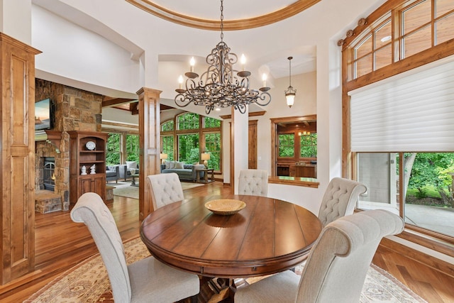 1904 Linner Rd, Minnetonka, MN 55391 - dining area with a high ceiling, wood-type flooring, ornate columns, a chandelier, and a fireplace