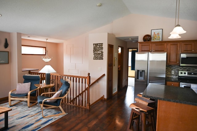 11764 35th Ave SE, Becker, MN 55308 - kitchen featuring stainless steel appliances, lofted ceiling, dark countertops, dark wood-style floors, and brown cabinetry