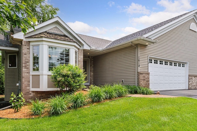 1614 Maple Manors Ct, Mound, MN 55364 - view of front of house featuring a front lawn, a garage, brick siding, driveway, and a shingled roof