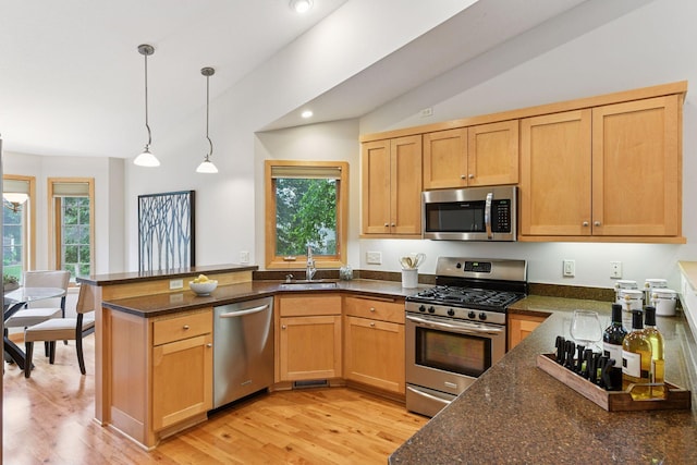 1614 Maple Manors Ct, Mound, MN 55364 - kitchen featuring appliances with stainless steel finishes, healthy amount of natural light, a peninsula, light wood-style floors, and lofted ceiling