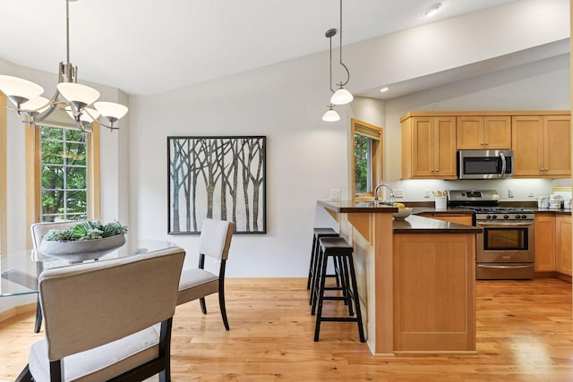 1614 Maple Manors Ct, Mound, MN 55364 - kitchen with appliances with stainless steel finishes, lofted ceiling, dark countertops, healthy amount of natural light, and a chandelier