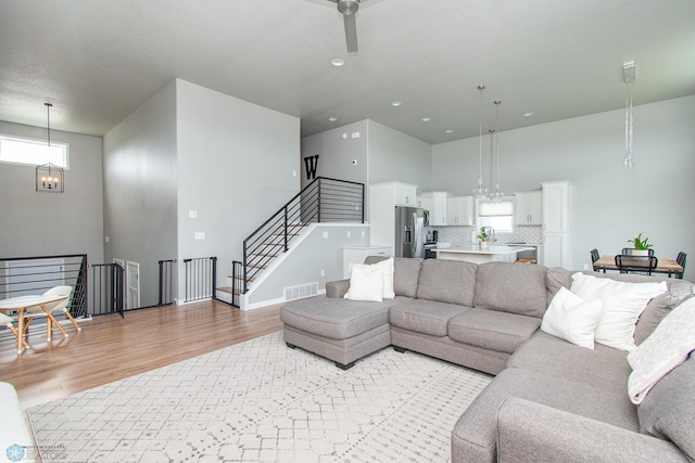 5252 8th Ct W, West Fargo, ND 58078 - living area with a chandelier, light wood finished floors, a high ceiling, a ceiling fan, and recessed lighting