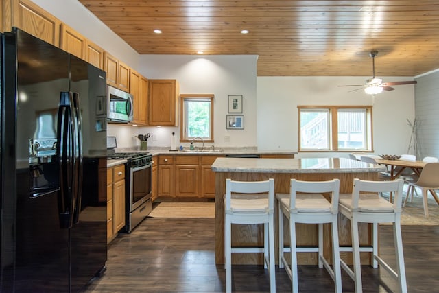 8290 Gladstone Lake Rd, Brainerd, MN 56401 - kitchen with stainless steel appliances, wood ceiling, a kitchen island, dark wood-style flooring, and a breakfast bar
