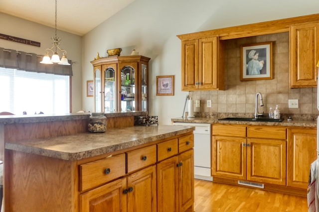 5010 384th Trl, North Branch, MN 55056 - kitchen featuring white dishwasher, lofted ceiling, decorative backsplash, brown cabinetry, and light wood-type flooring