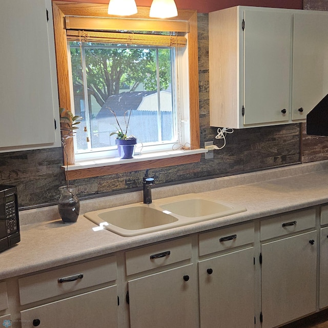 327 6th Ave, Mapleton, ND 58059 - kitchen with tasteful backsplash, light countertops, black microwave, and white cabinetry