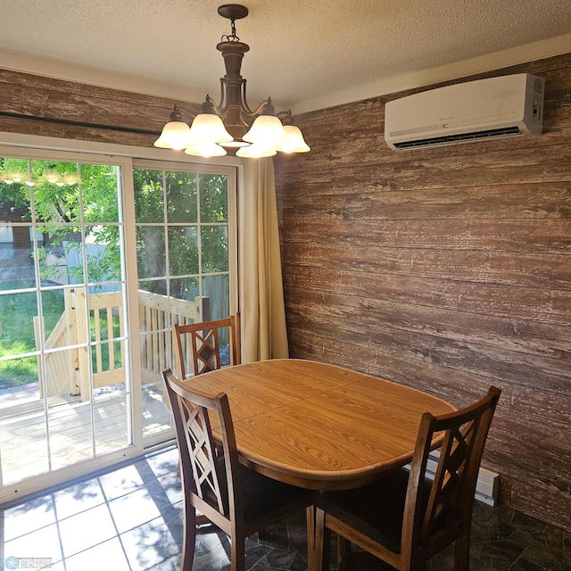 327 6th Ave, Mapleton, ND 58059 - dining room with a wall unit AC, wooden walls, a chandelier, and a textured ceiling