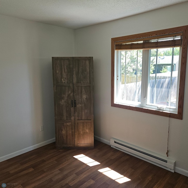 327 6th Ave, Mapleton, ND 58059 - unfurnished bedroom featuring baseboard heating and dark wood-style flooring