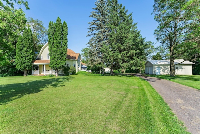 11826 State Road 48, Frederic, WI 54837 - view of grassy yard featuring an outbuilding, a detached garage, and a porch