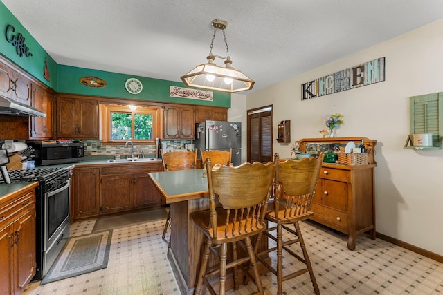 11826 State Road 48, Frederic, WI 54837 - kitchen with stainless steel appliances, under cabinet range hood, backsplash, a center island, and a breakfast bar area