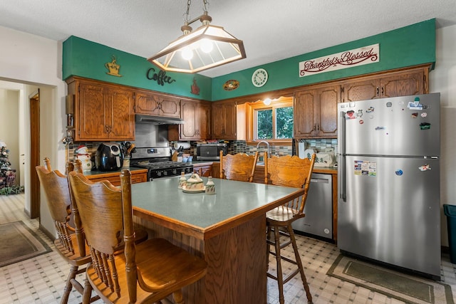 11826 State Road 48, Frederic, WI 54837 - kitchen featuring stainless steel appliances, light floors, under cabinet range hood, backsplash, and a textured ceiling