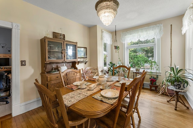 11826 State Road 48, Frederic, WI 54837 - dining space with light wood-style floors, a chandelier, and a textured ceiling