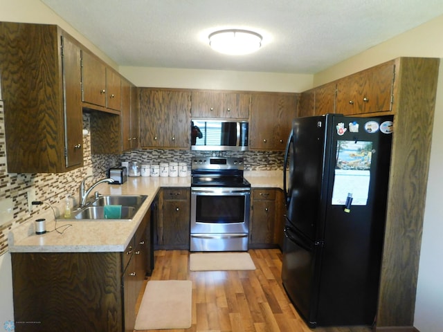961 4th Ave W Unit B, West Fargo, ND 58078 - kitchen featuring stainless steel appliances, light wood-style flooring, light countertops, and decorative backsplash