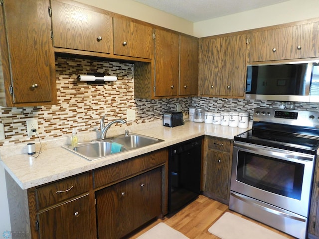 961 4th Ave W Unit B, West Fargo, ND 58078 - kitchen featuring stainless steel appliances, light countertops, tasteful backsplash, and light wood-style flooring