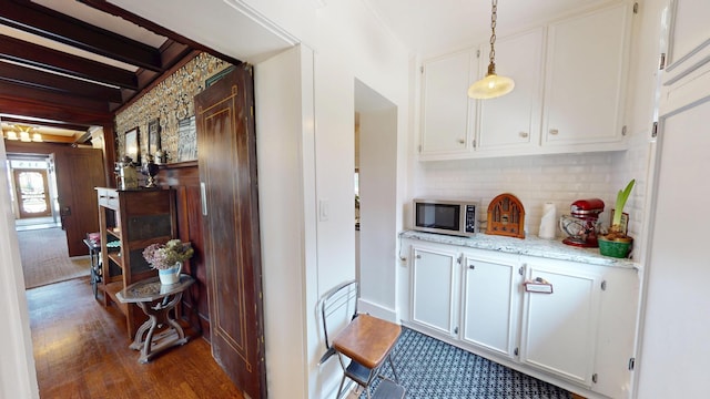 315 Fountain St, Albert Lea, MN 56007 - bar area featuring stainless steel microwave, backsplash, dark wood-type flooring, pendant lighting, and beam ceiling