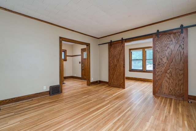 616 5th St, Mankato, MN 56001 - empty room with a barn door, light wood-style floors, and ornamental molding