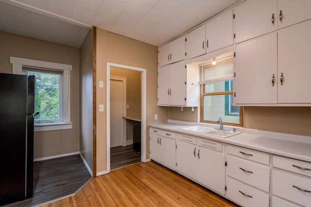 616 5th St, Mankato, MN 56001 - kitchen with freestanding refrigerator, light wood-type flooring, white cabinetry, and light countertops