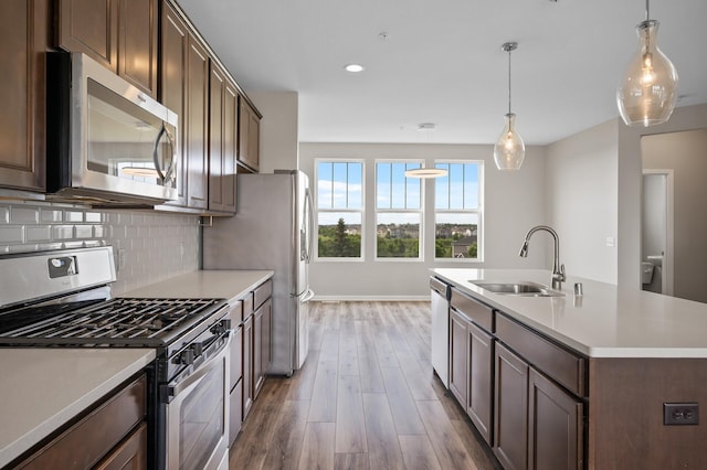 15484 Eames Way, Apple Valley, MN 55124 - kitchen with stainless steel appliances, wood finished floors, light countertops, decorative backsplash, and an island with sink
