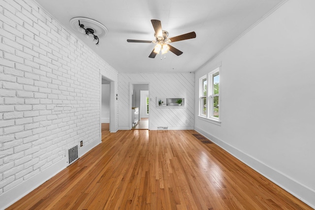 1175 Seminary Ave, Saint Paul, MN 55104 - unfurnished living room featuring ceiling fan, brick wall, and light wood-style floors