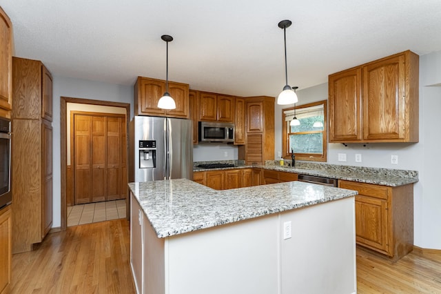 2319 Viola View Ln NE, Rochester, MN 55906 - kitchen with stainless steel appliances, light wood-type flooring, brown cabinets, a center island, and light stone countertops