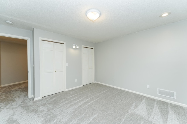 2319 Viola View Ln NE, Rochester, MN 55906 - unfurnished bedroom with multiple closets, carpet floors, and a textured ceiling