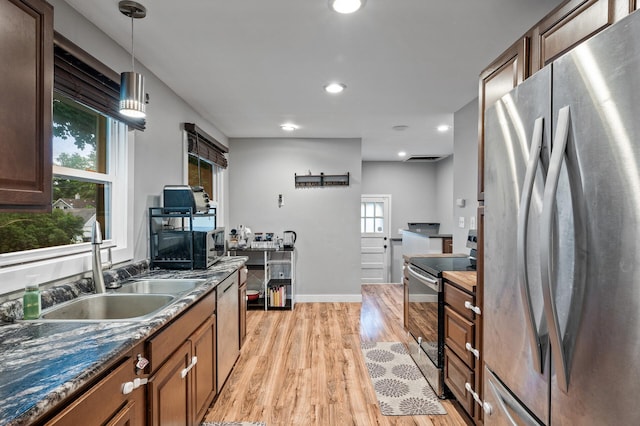 3256 Sheridan Ave N, Minneapolis, MN 55412 - kitchen featuring appliances with stainless steel finishes, light wood-style flooring, decorative light fixtures, dark countertops, and recessed lighting