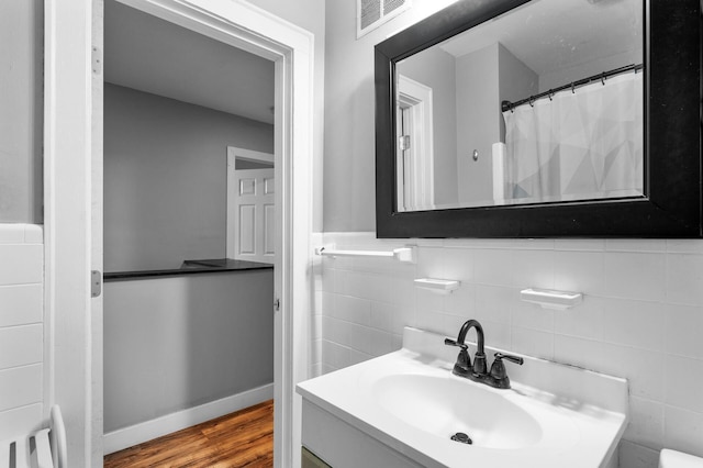 3256 Sheridan Ave N, Minneapolis, MN 55412 - full bathroom with tile walls, wood finished floors, and vanity