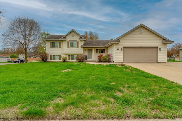 704 Main St, Madelia, MN 56062 - tri-level home featuring an attached garage, concrete driveway, a front lawn, and a shingled roof