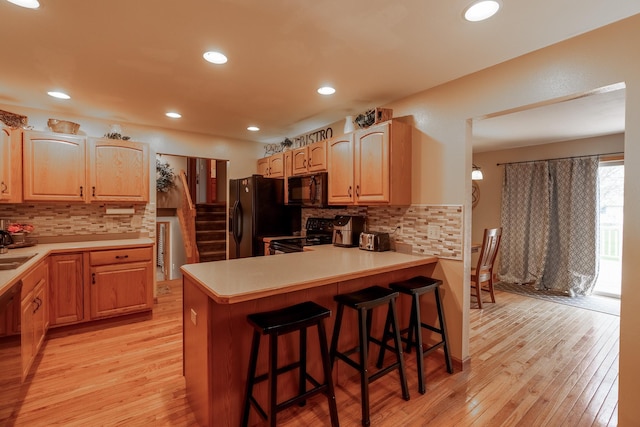 704 Main St, Madelia, MN 56062 - kitchen with black appliances, light wood-style flooring, backsplash, and recessed lighting